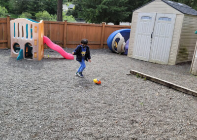 Kindergartener Playing - Kicking a ball at school - Renton, WA